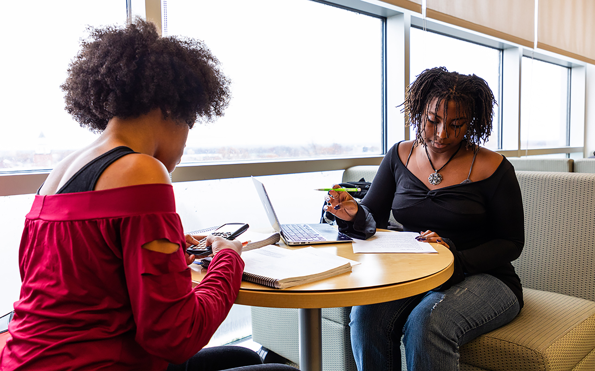 A student tutor assists another student with coursework